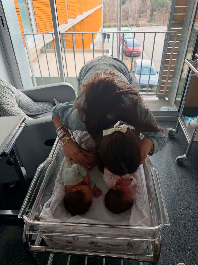 Estela besa a sus hijos, que descansan juntos en la cunita del hospital