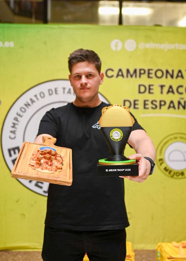 El ganador de este año, posando con su trofeo y sus tacos vencedores.