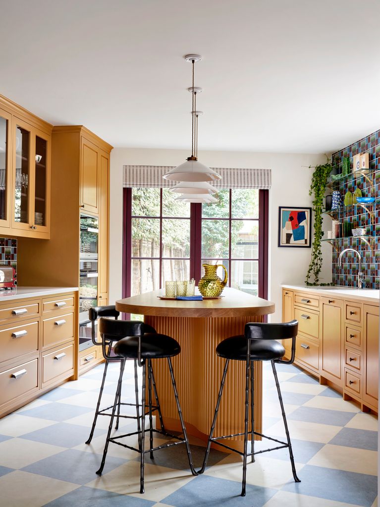 Cocina con isla central y muebles de madera en dos frentes     