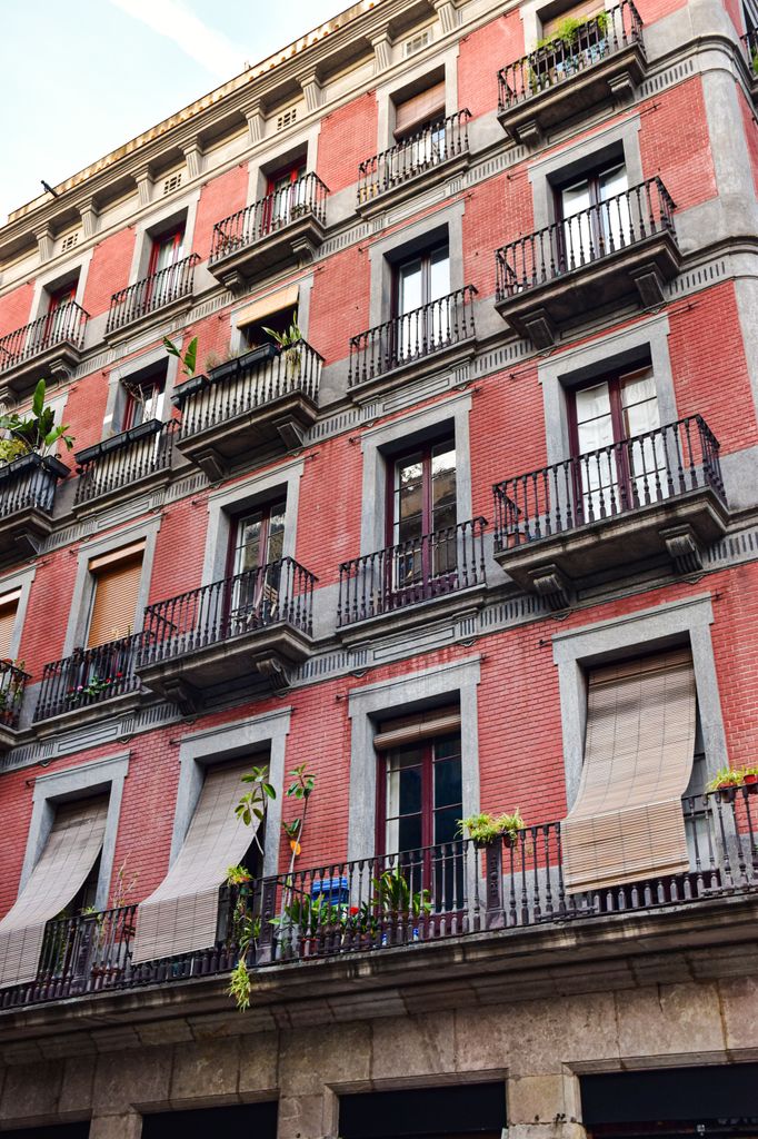 Fachada de un bloque de pisos antiguo con sistemas de protección como persianas de madera exterior
