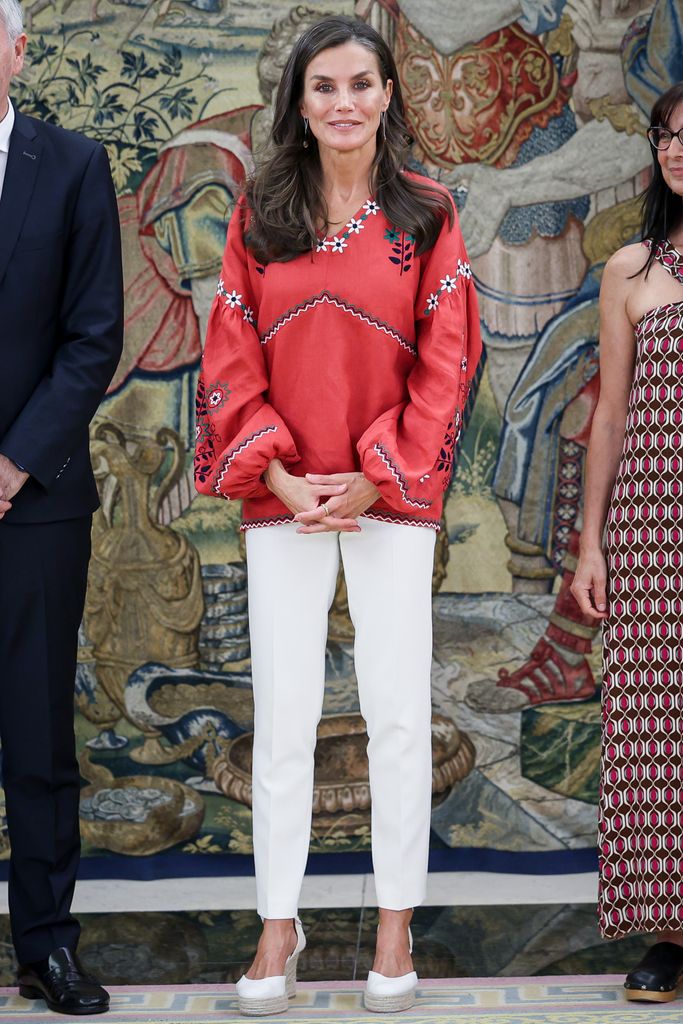 Reina Letizia con pantalones blancos, alpargatas y blusa roja en el Palacio de la Zarzuela