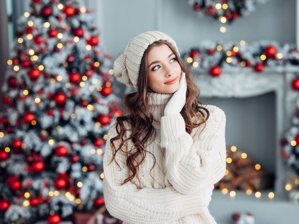 Chica en la noche de Navidad con el árbol de fondo