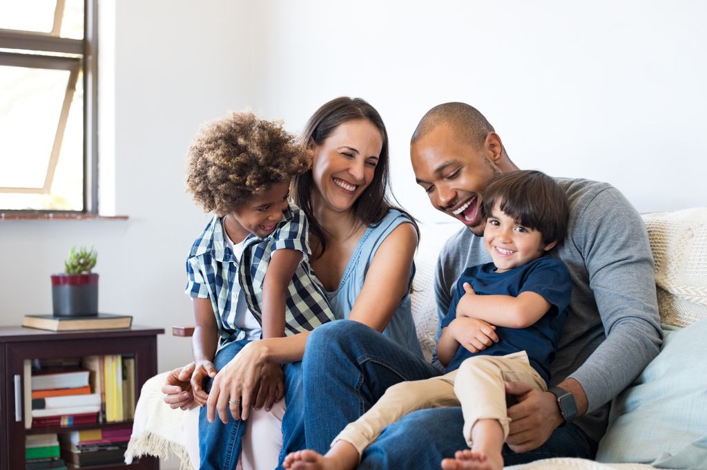 Familia enlazada feliz en el salón
