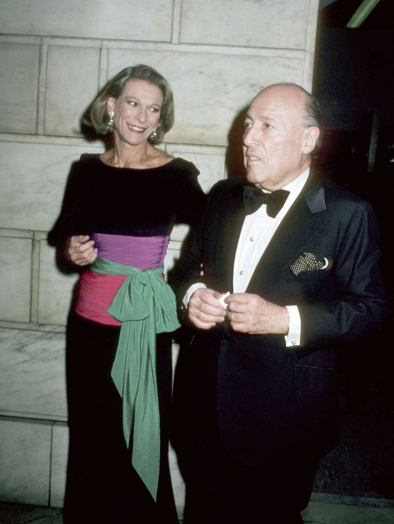 Nan Kempner con vestido negro y fajín multicolor