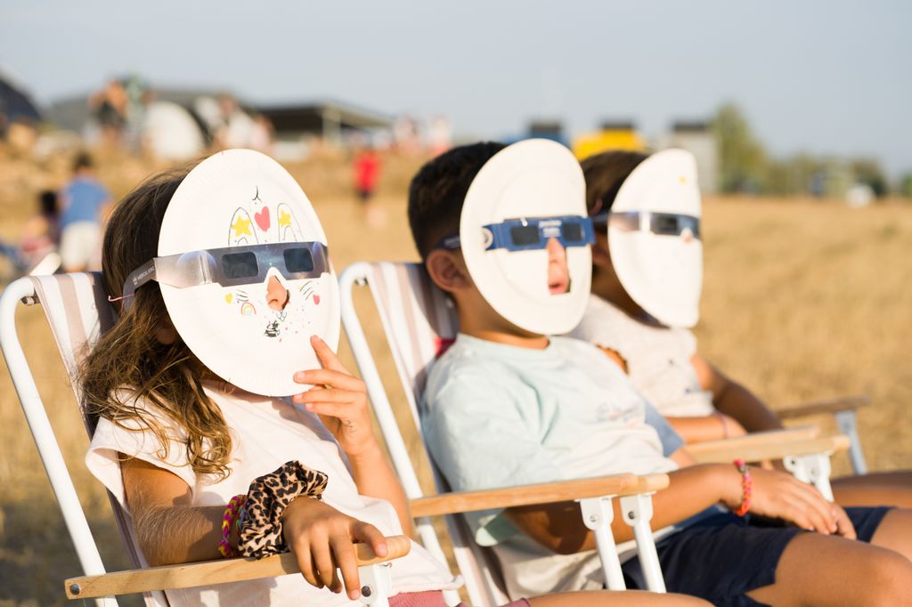 Un grupo de niños sigue el eclipse desde Aras de los Olmos, en Valencia, protegido con gafas especiales incorporadas a unas originales máscaras caseras.
