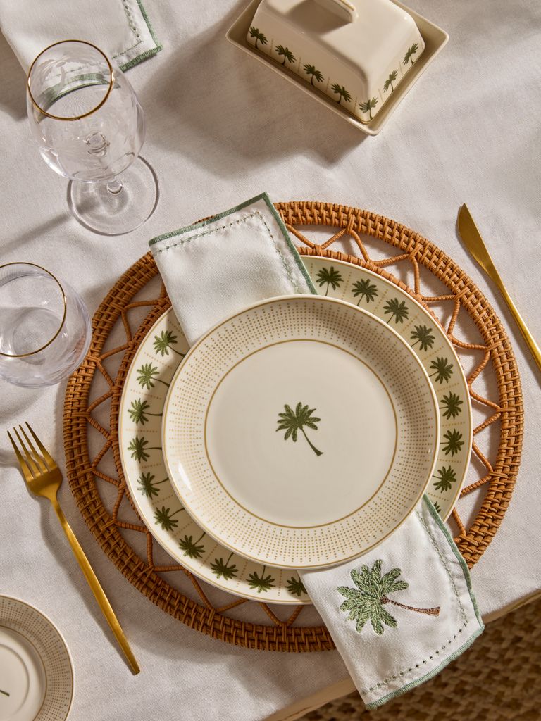 Mesa de verano con platos con dibujos de palmera