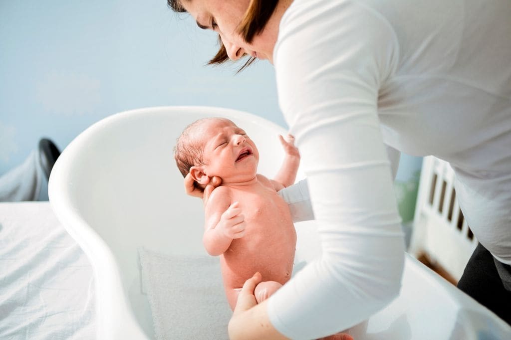 Madre baña a recién nacido
