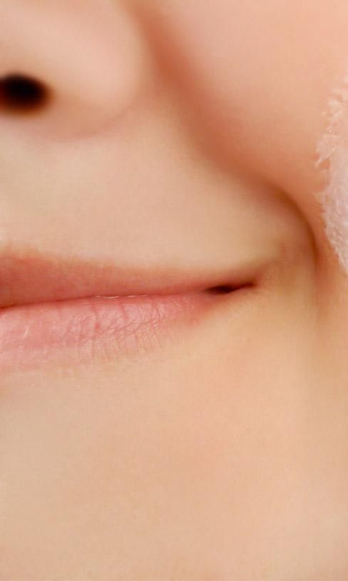 mujer sonriente aplica crema en la cara