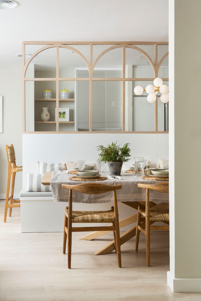 Comedor separado de la cocina con pared de cristal.