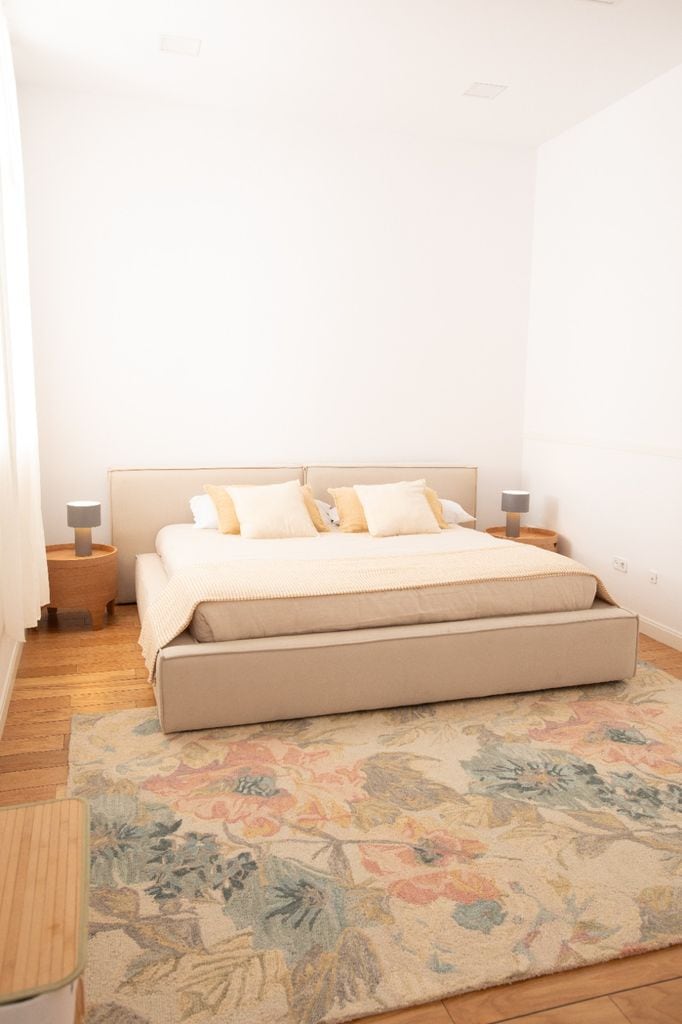 Dormitorio con cama tapizada en beis