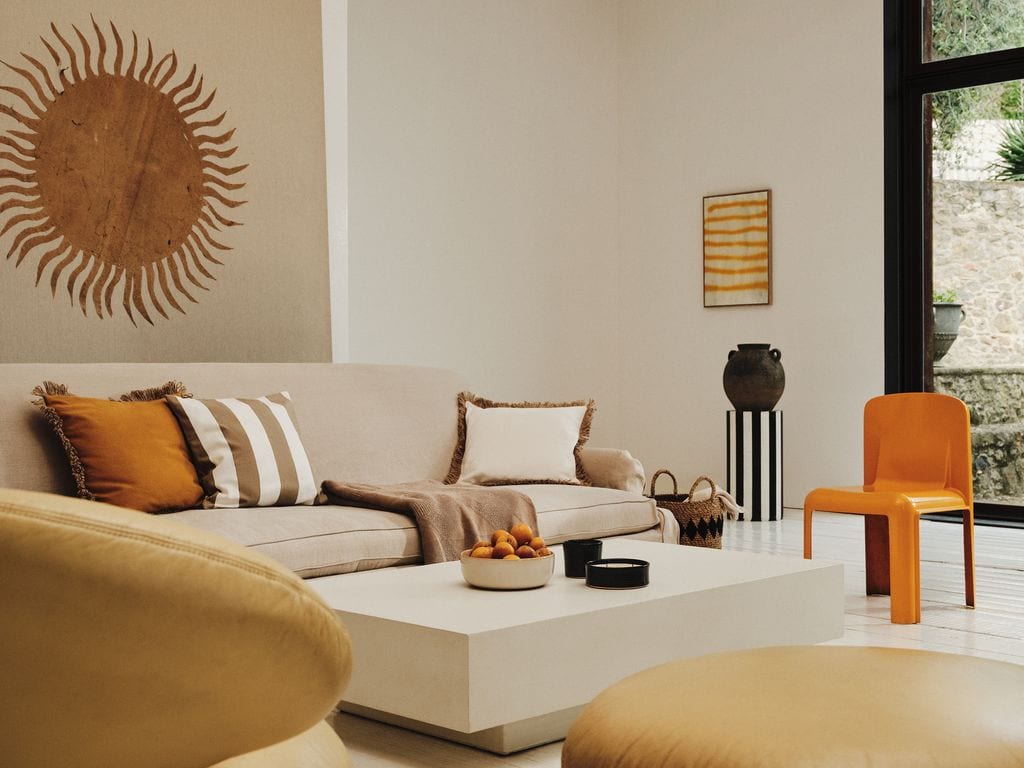 Salón decorado en tonos neutros con toques naranjas y marrones