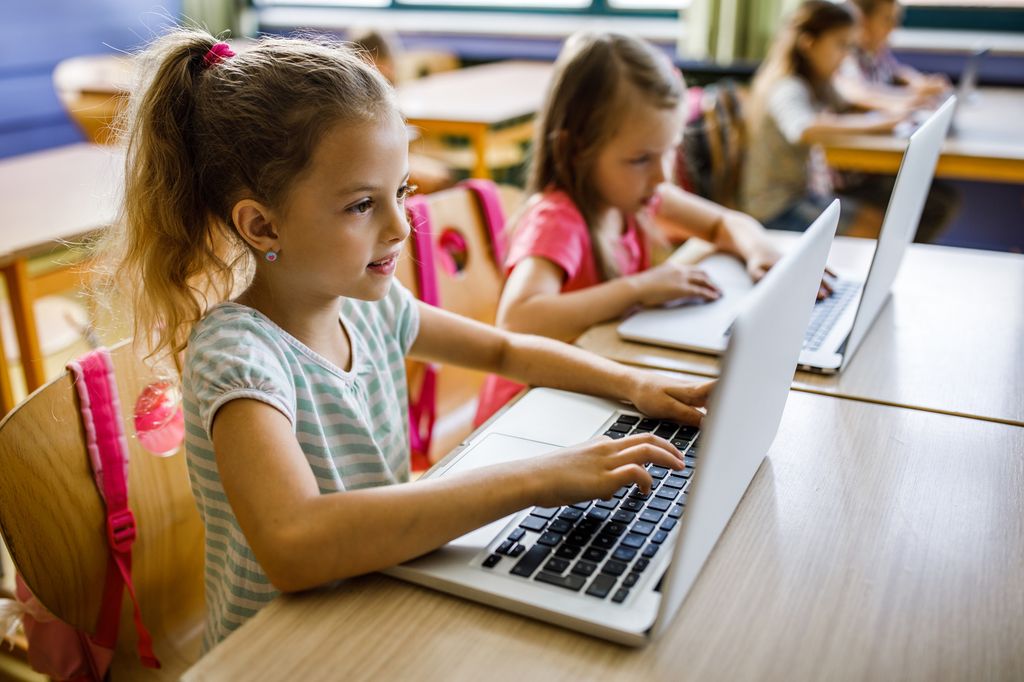 Niñas con un ordenador portátil en clase