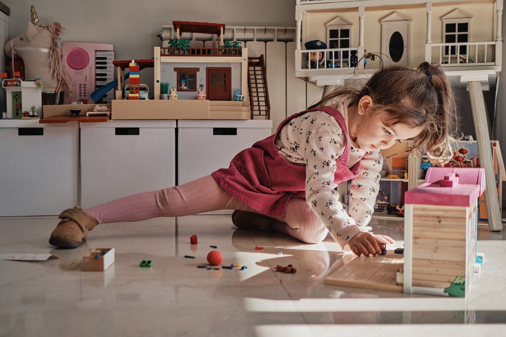 Niña jugando en su casa de muñecas
