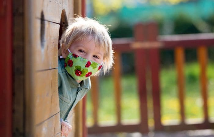 Niño con mascarilla en un parque