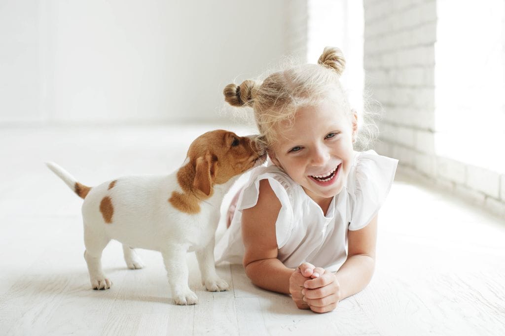 Niña sonriente con cachorro de perro