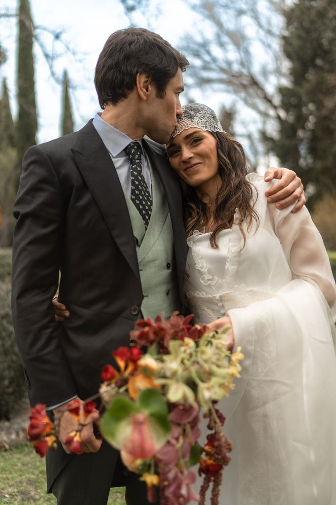 Vestido de novia de Vocot con ramo con cascada y velo mantilla