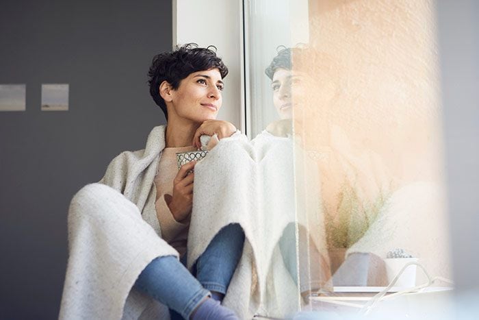 mujer relajada mirando por la ventana