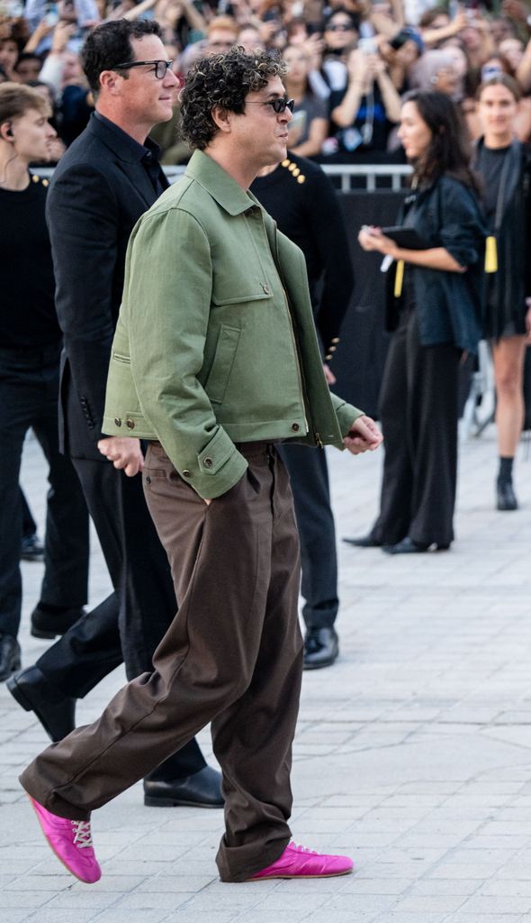 Beto Montenegro lució un atuendo café con verde militar y un inesperado pop de color fucsia.
