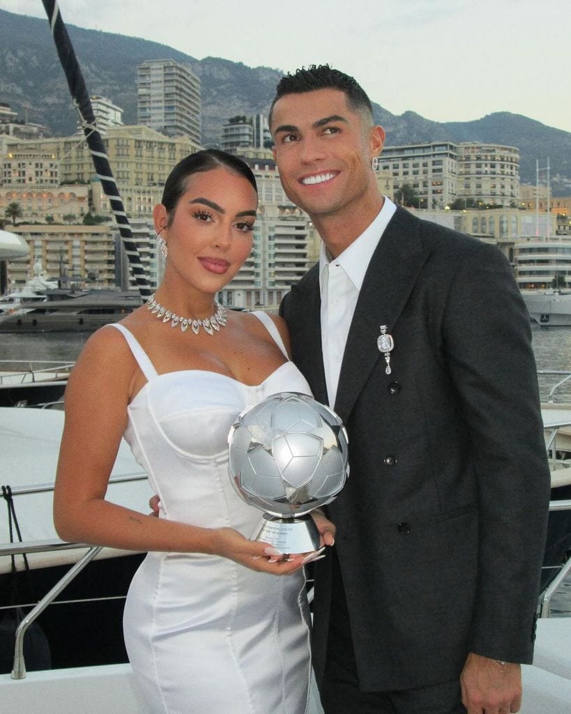 Plano medio de Cristiano Ronaldo y Georgina Rodríguez posando con el Premio Especial de la UEFA