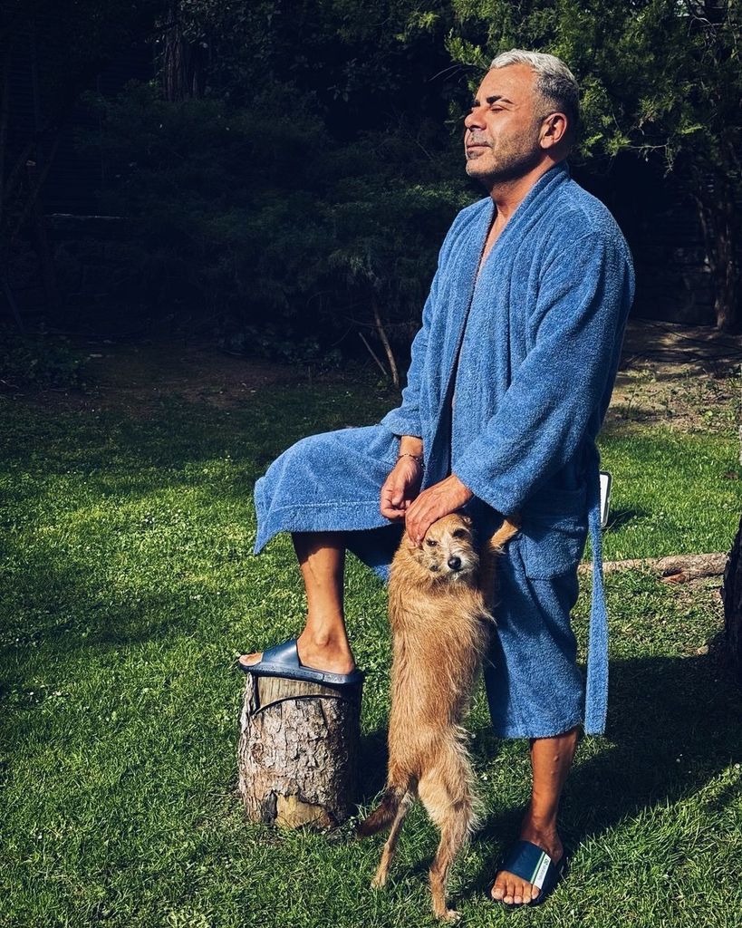 Plano entero de Jorge Javier Vázquez posando en albornoz con su mascota