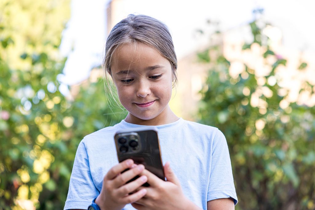 Niña usa las redes sociales en su móvil