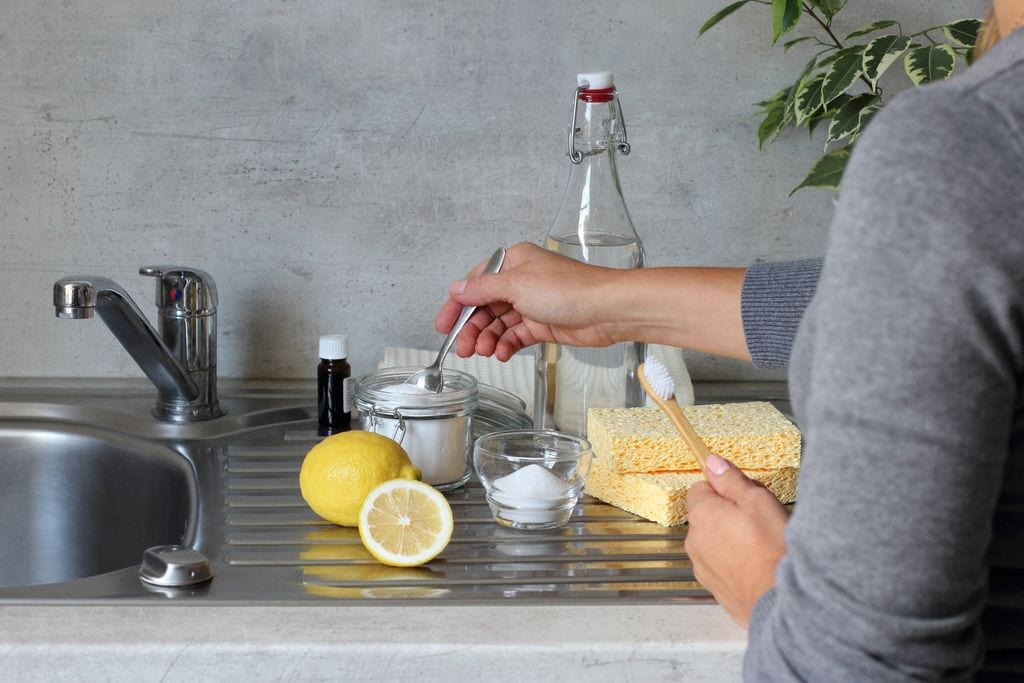 mujer utilizando bicarbonato y limón como remedio casero