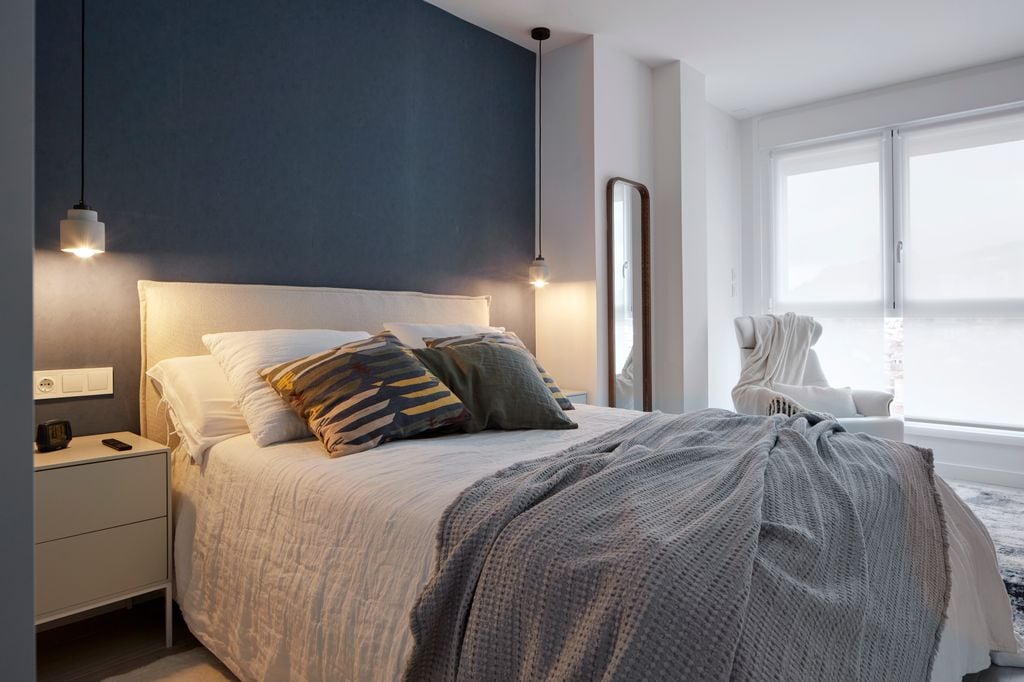 Dormitorio amplio con un espejo de cuerpo entero que no muestra la cama, refleja una bonita zona de tocador