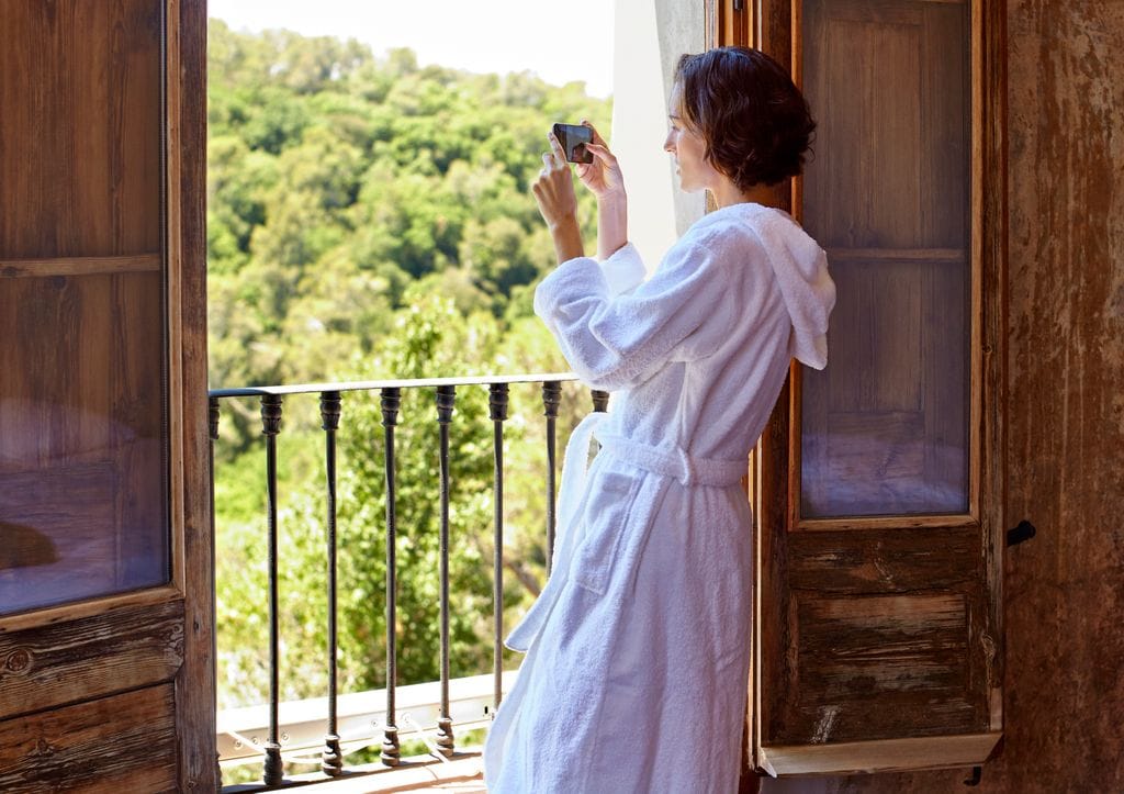 Mujer en albornoz de vacaciones disfrutando de las vistas