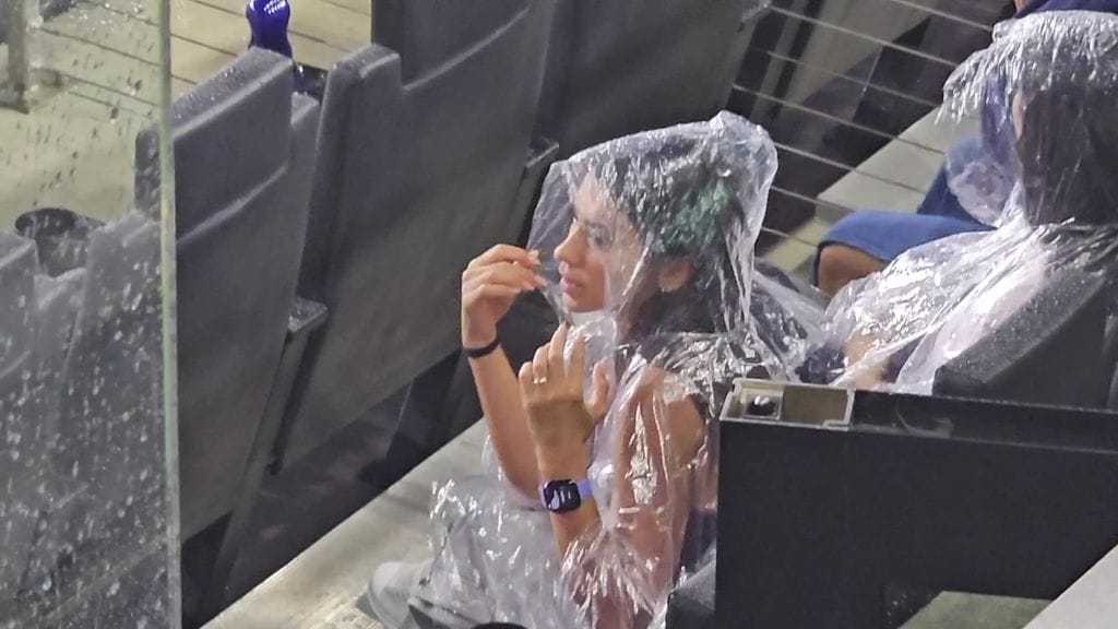 Antonela Roccuzzo echó mano de un sencillo impermeable de plástico para protegerse de la lluvia.