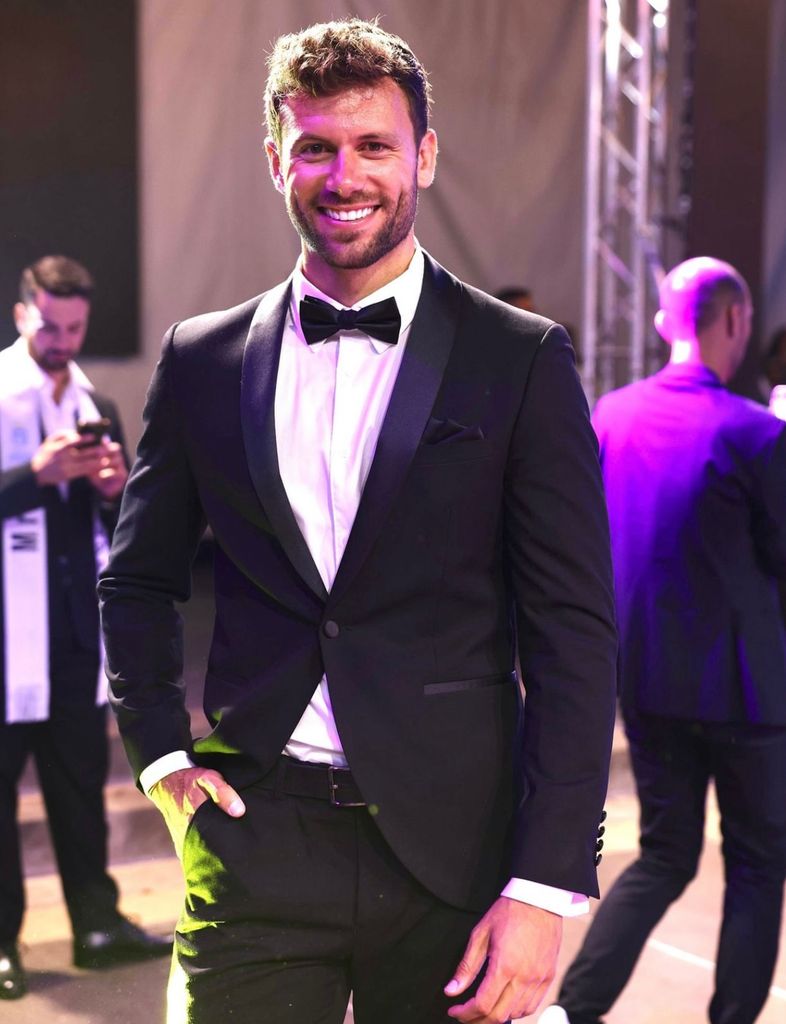 Toni Company en un evento con traje negro