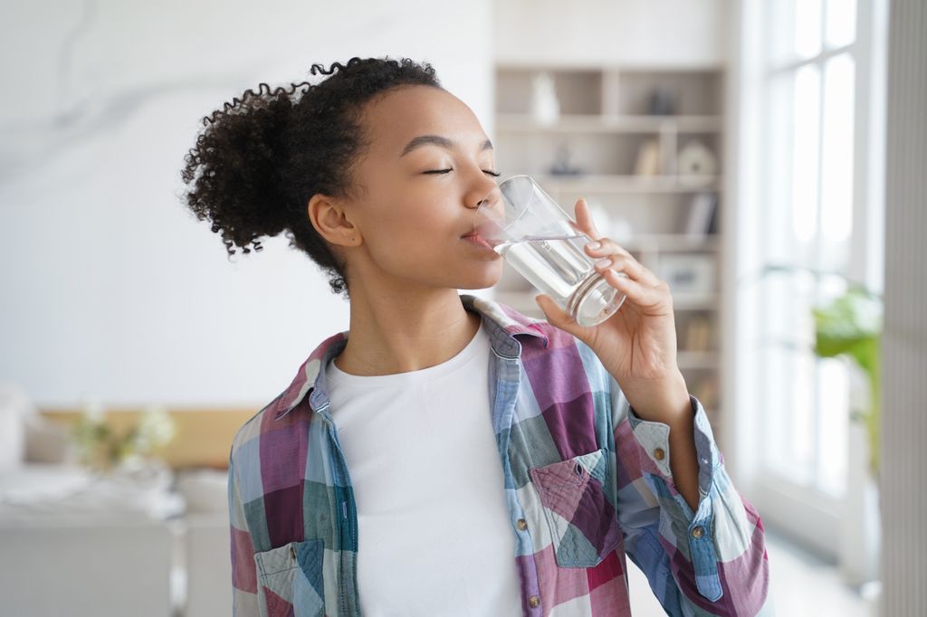 Adolescente tomando un vaso de agua en la dieta de las princesas Disney