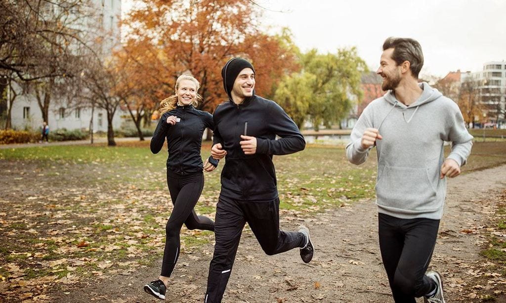 Pequeño grupo de personas corriendo en el parque juntos.