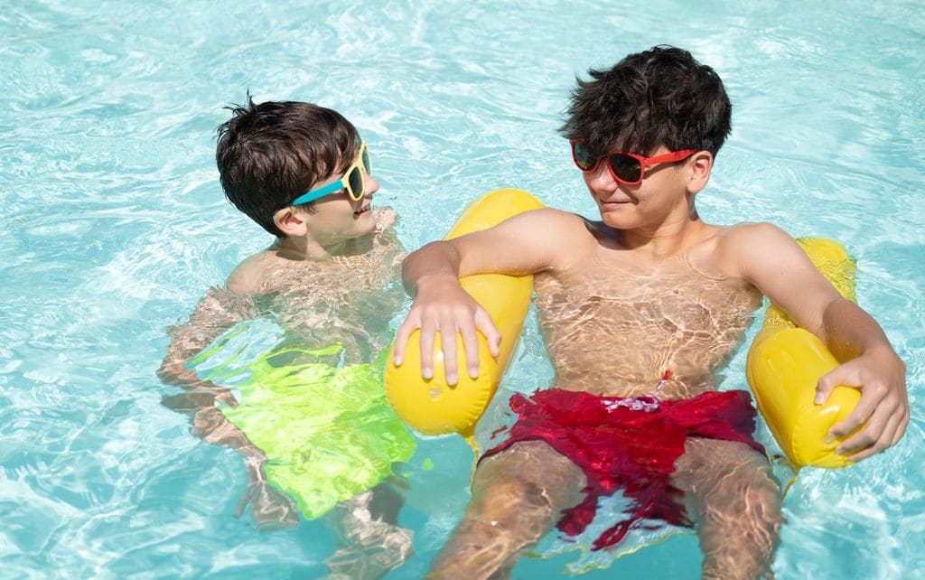 Hermanos juntos en la piscina