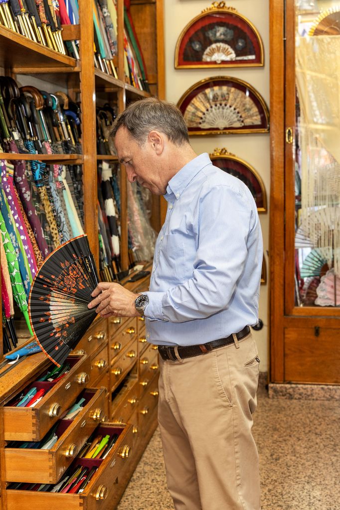 Arturo Llerandi organizando los abanicos en la tienda