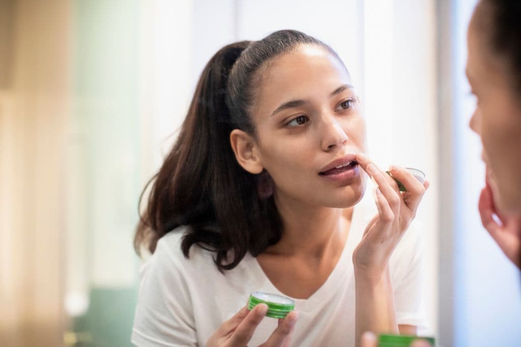 mujer aplicándose bálsamo labial
