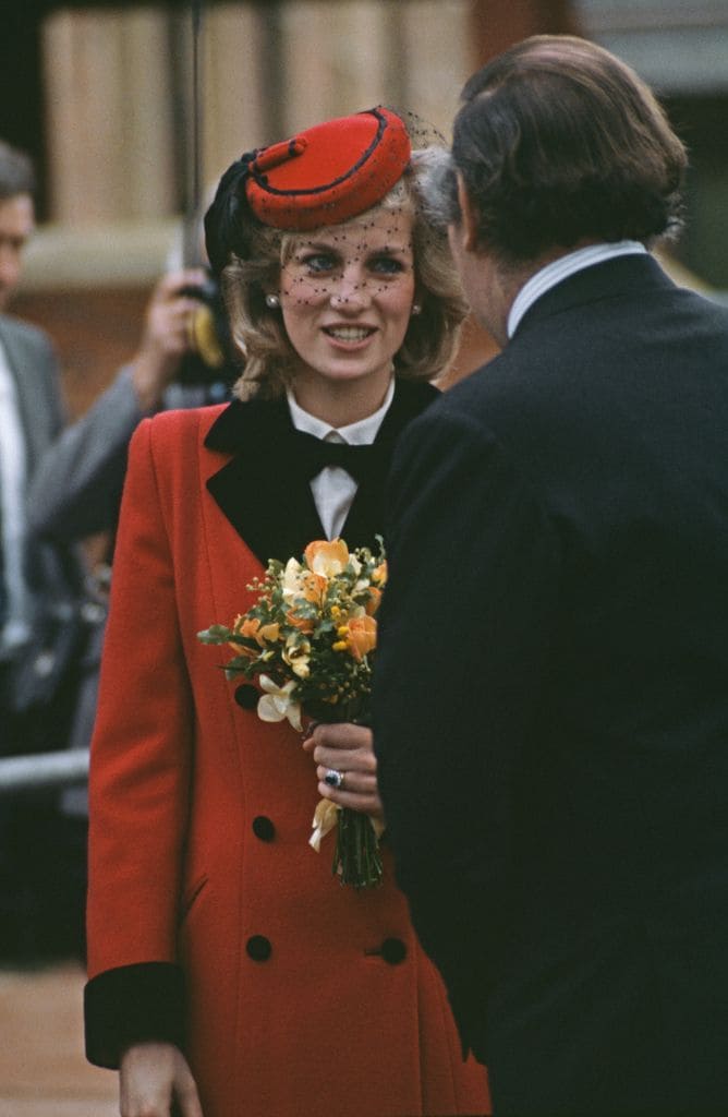 Diana, princesa de Gales, con un abrigo rojo en 1984 en el aeropuerto de Birmingham.