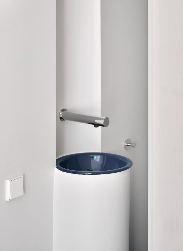 Lavabo de forma cilíndrica y grifo de pared