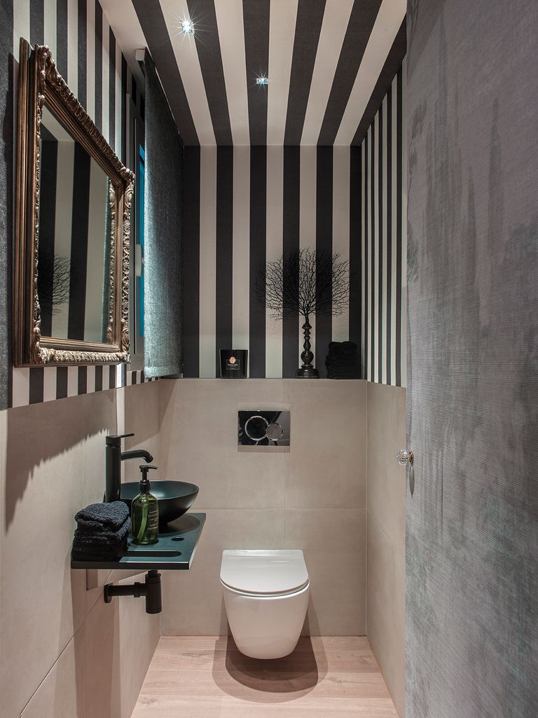 Baño con inodoro con cisterna empotrada.