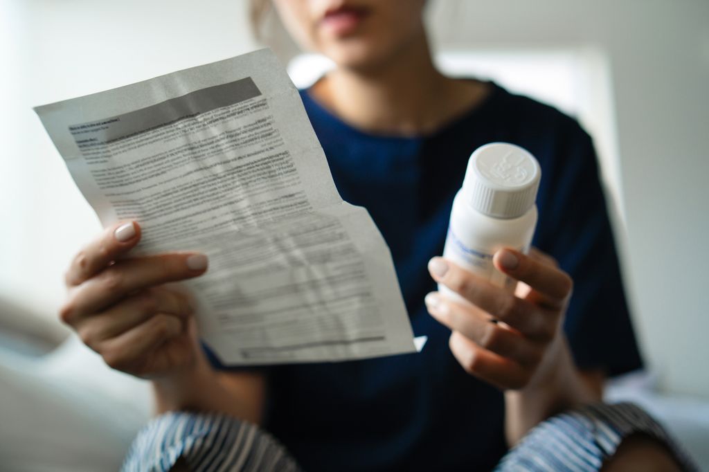 Mujer embarazada con medicacion en la mano