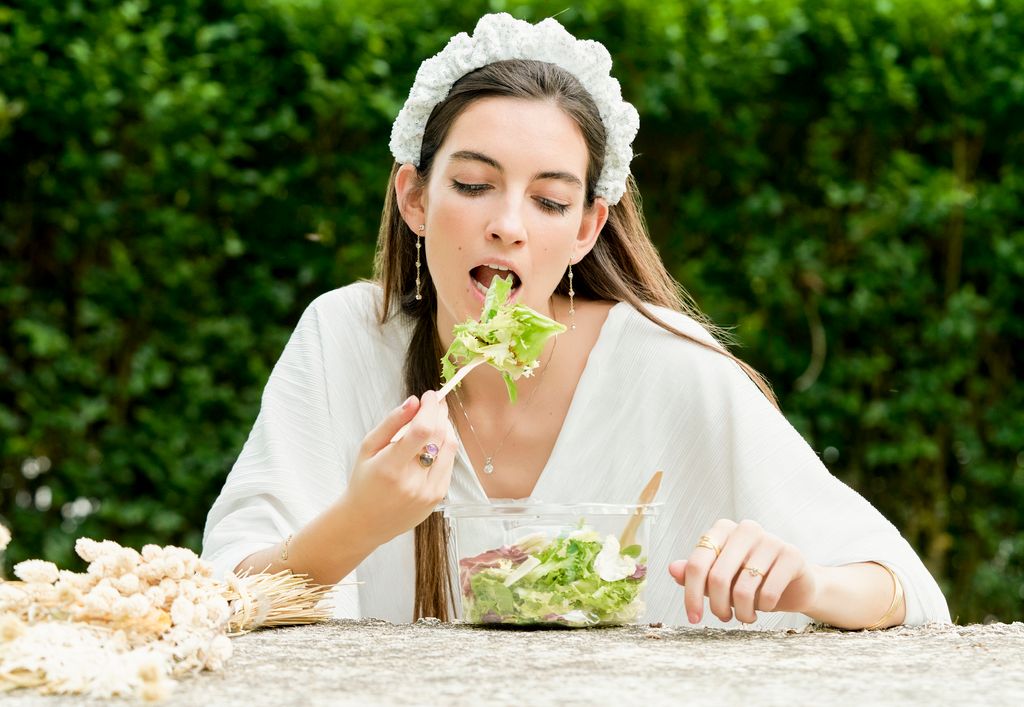 Mujer comiendo una ensalada en el campo