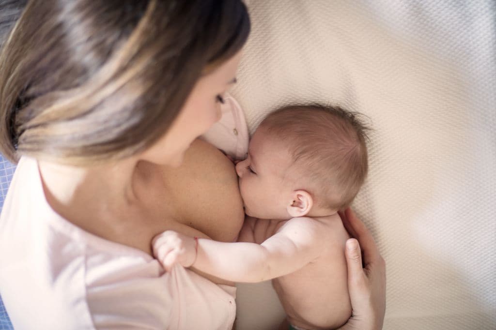 Madre dando de mamar a su hijo