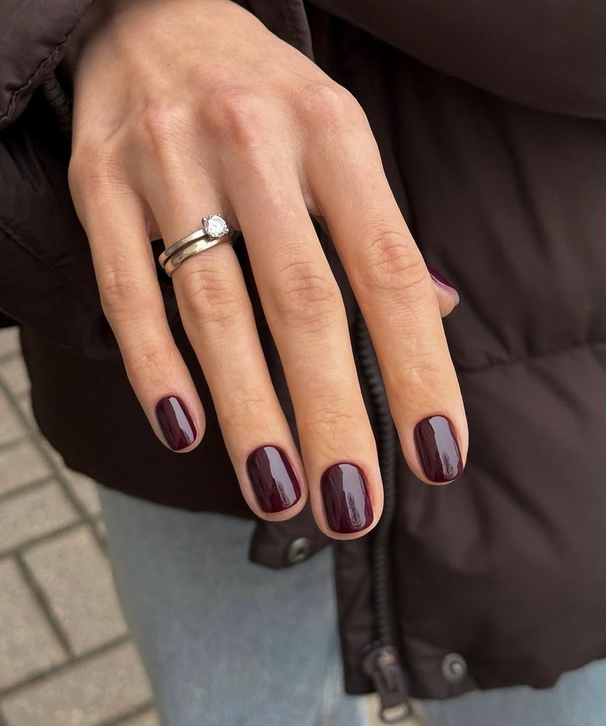 Primer plano de manos con manicura burdeos cereza