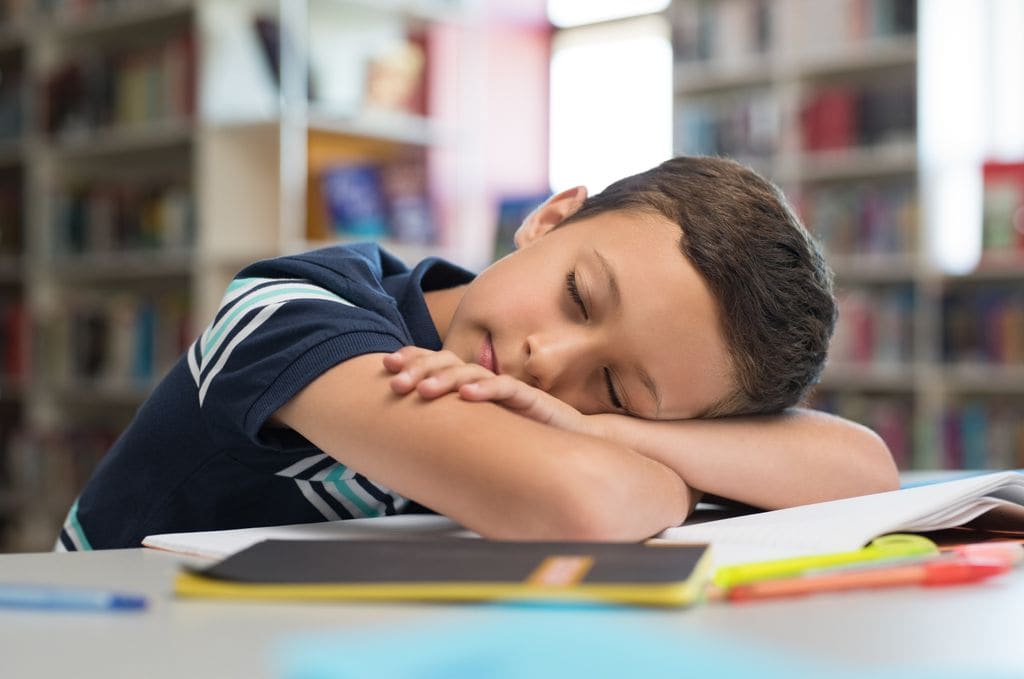 Niño con narcolepsia dormido en el colegio
