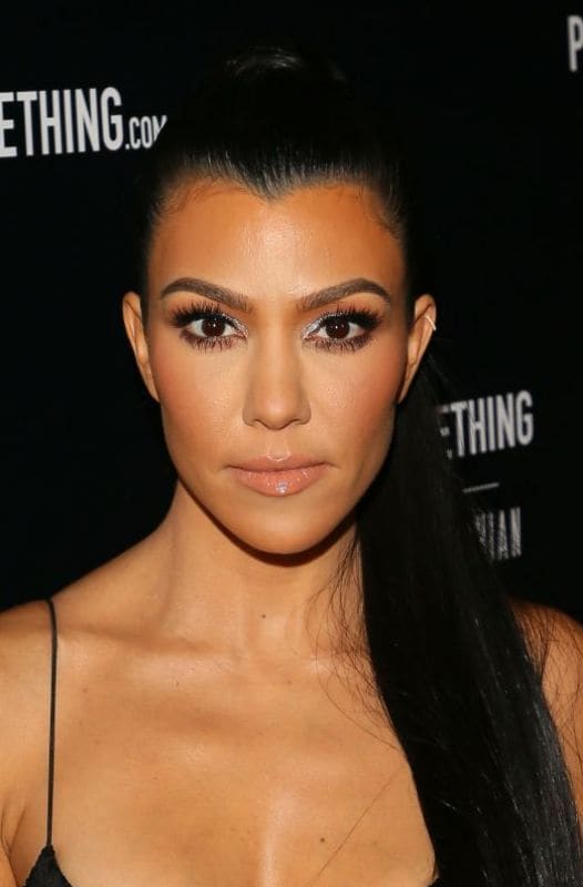 Kourtney Kardashian con cola de cabello, contorneado ligero y vestido negro 