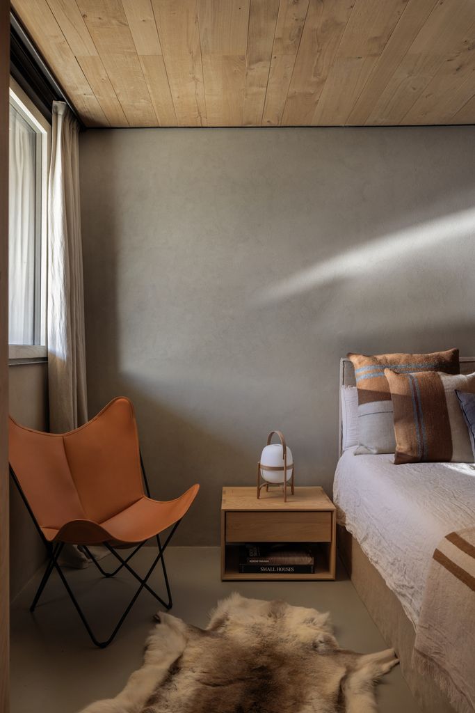 Dormitorio con silla butterfly en piel marrón