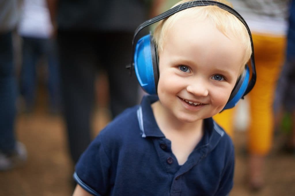 Niño con cascos antirruido en un festival de música