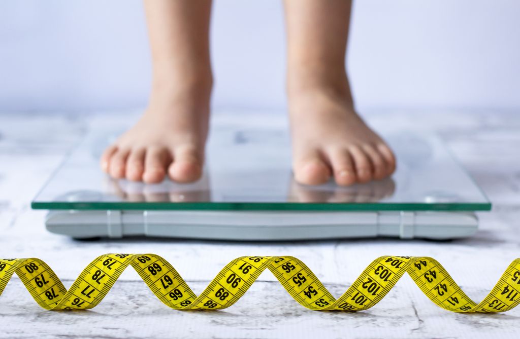 Niño pesándose en una báscula