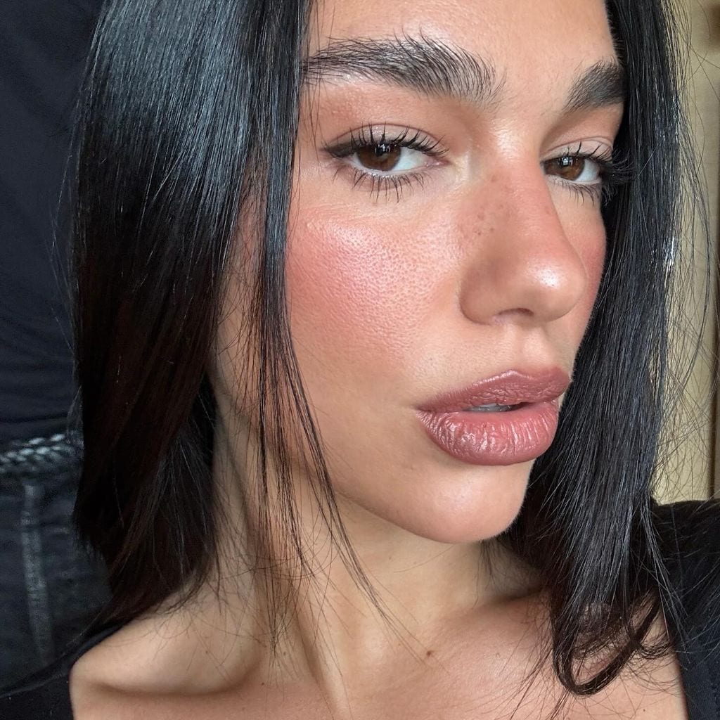 Dua Lipa con maquillaje natural de colorete, pecas y labial nude