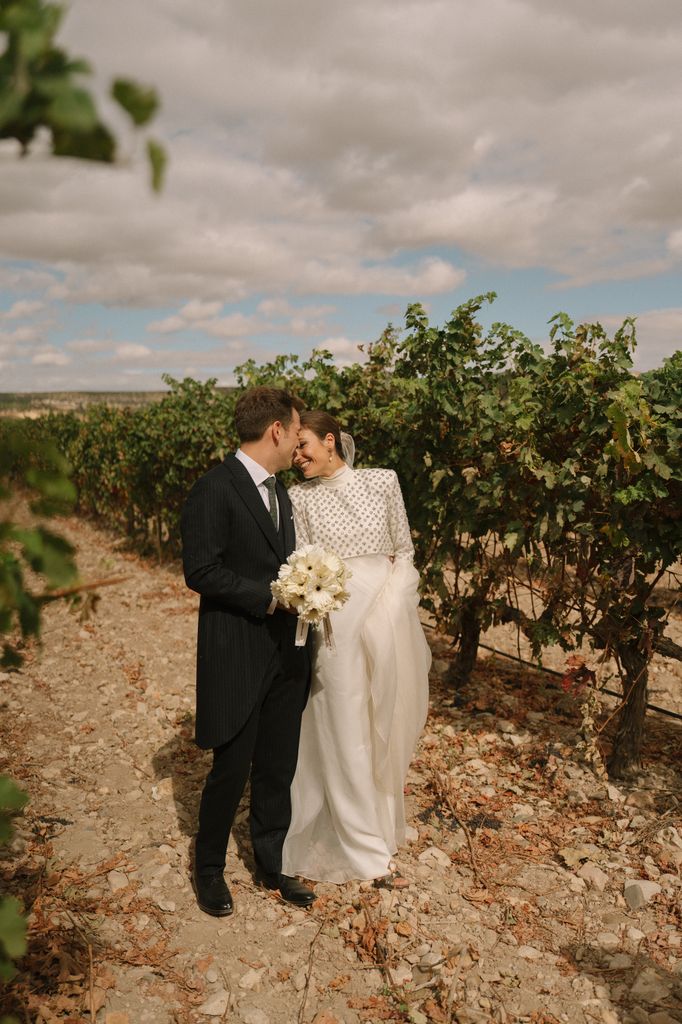 Vestido de novia con torera joya de Cotonnus y ramo de gerberas