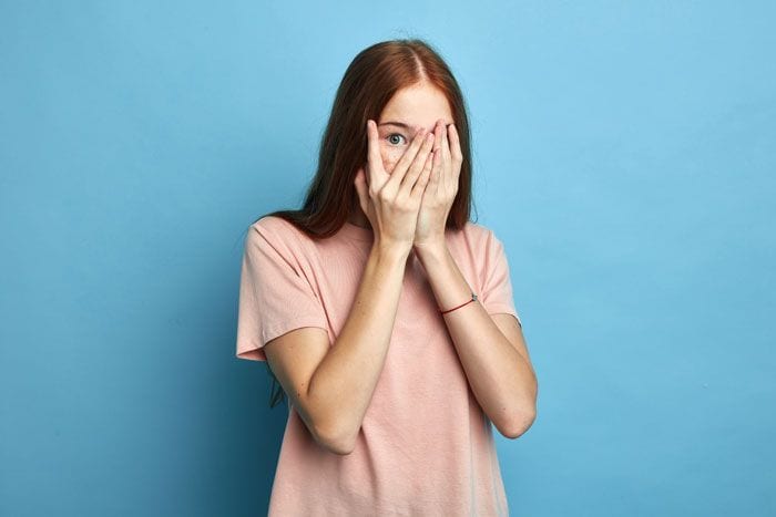 mujer que se esconde detrás de sus manos